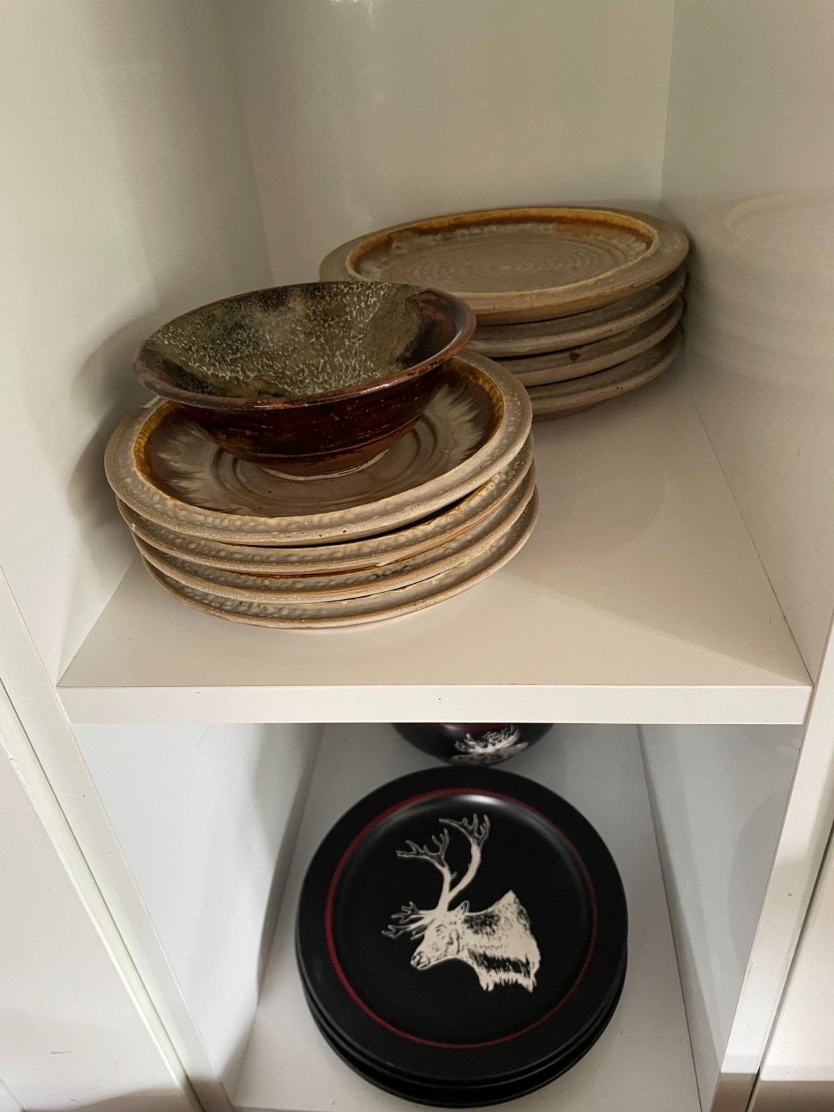 Handmade stoneware plates and bowls in the cupboard