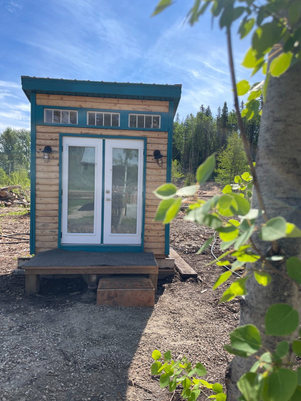 The little teal-trimmed washhouse among the trees